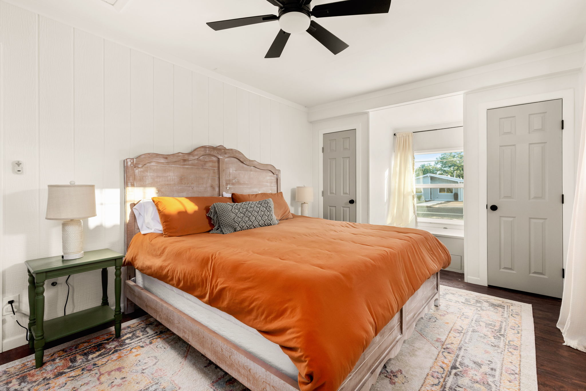 Primary bedroom with orange linen bedding
