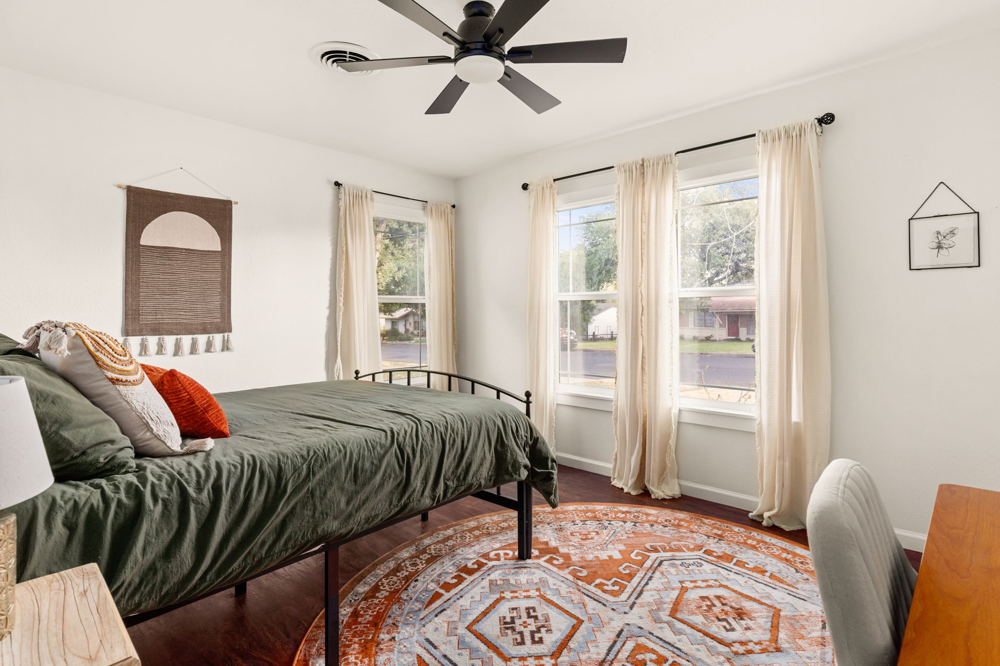 Second bedroom with green bedding and boho wall art