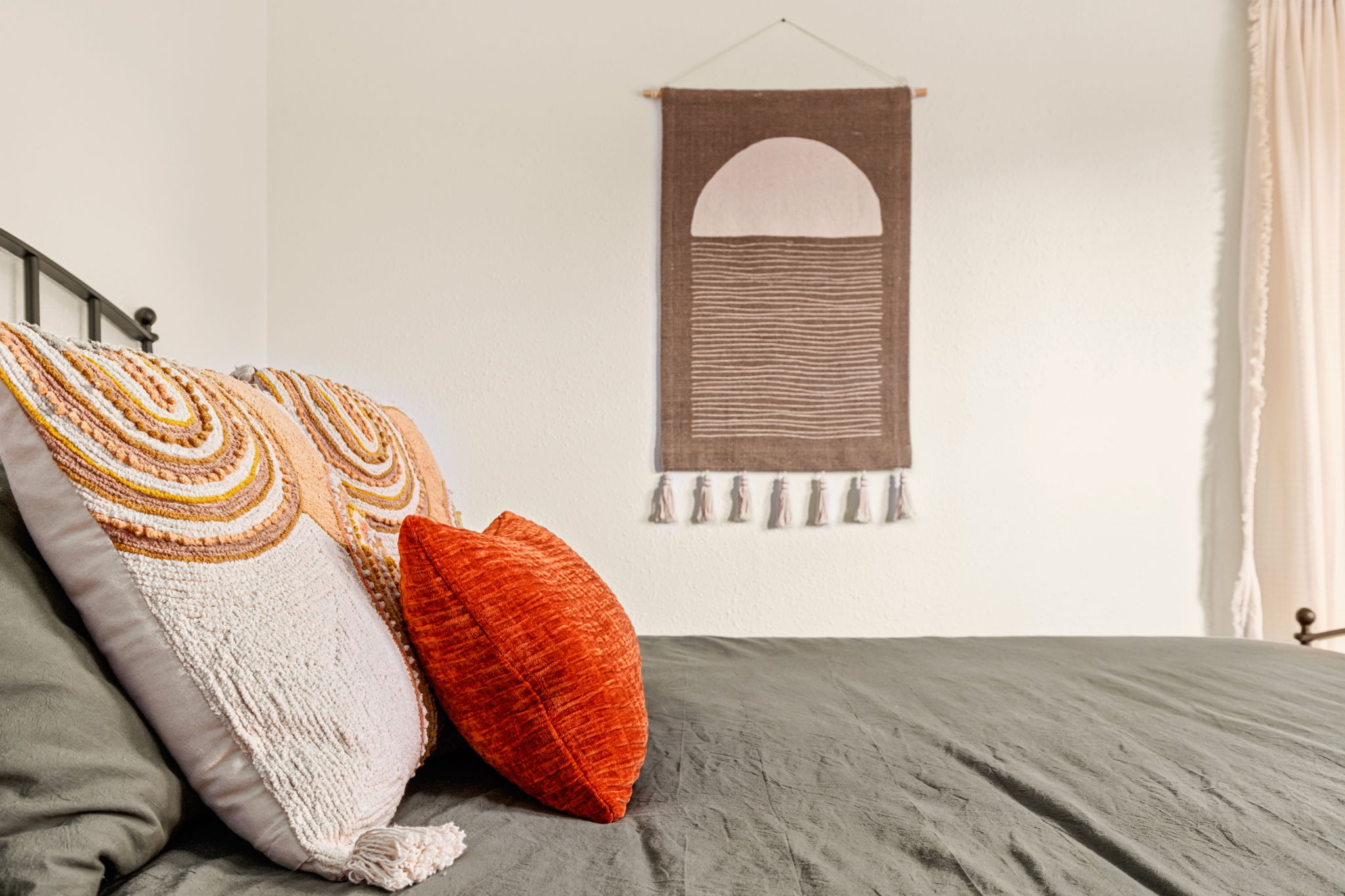 Boho pillow detail with tapestry wall hanging