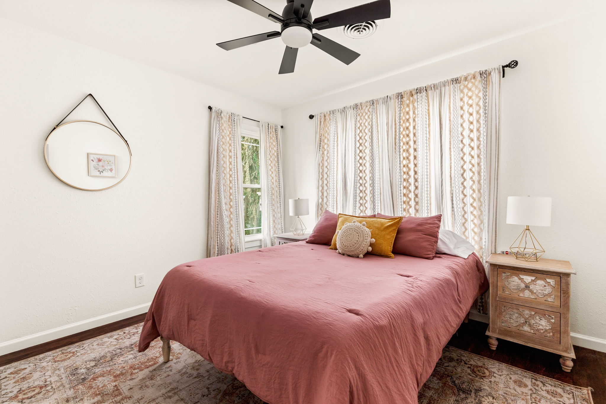 Third bedroom with pink linen and boho curtains