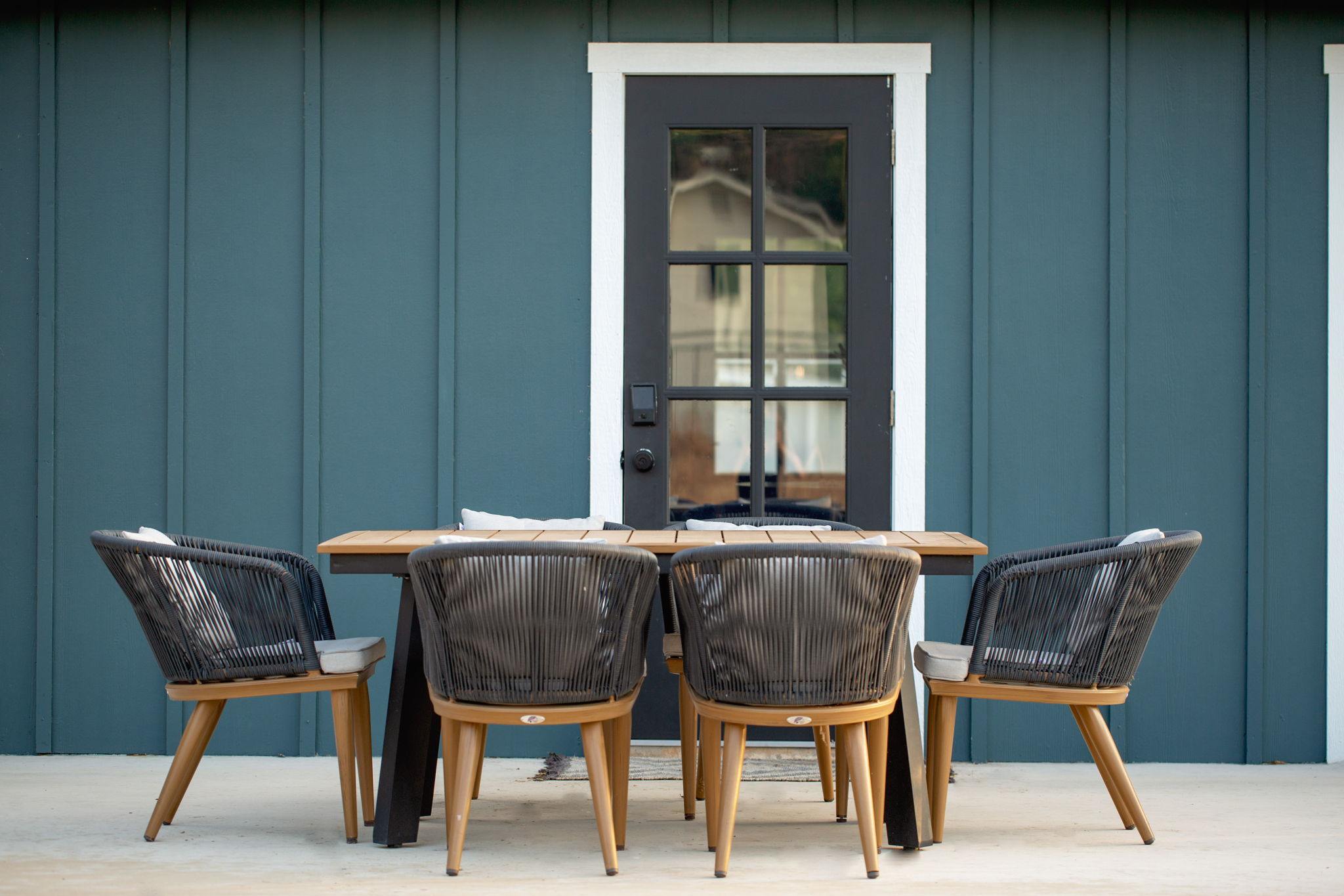 Outdoor dining table against teal exterior wall