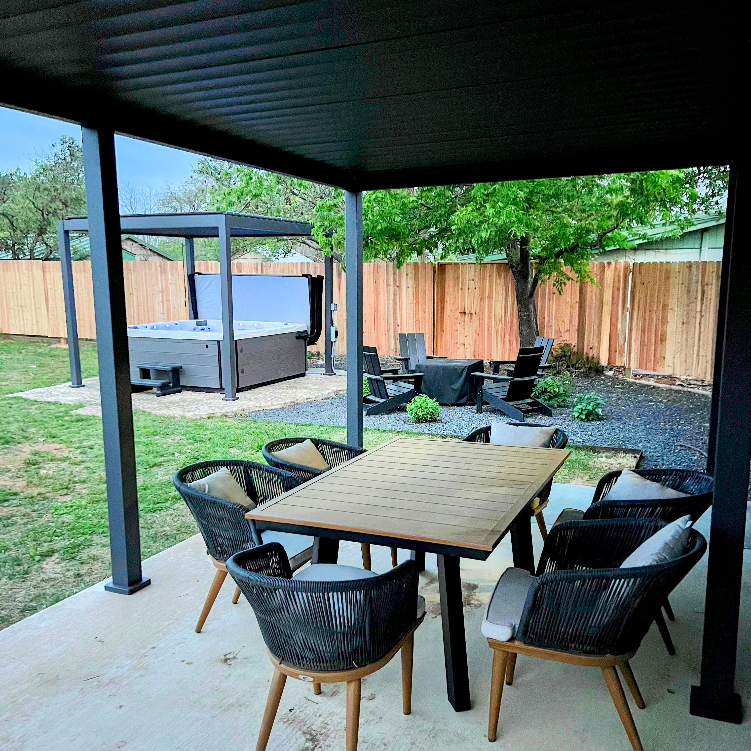 Covered pergola with outdoor dining and hot tub