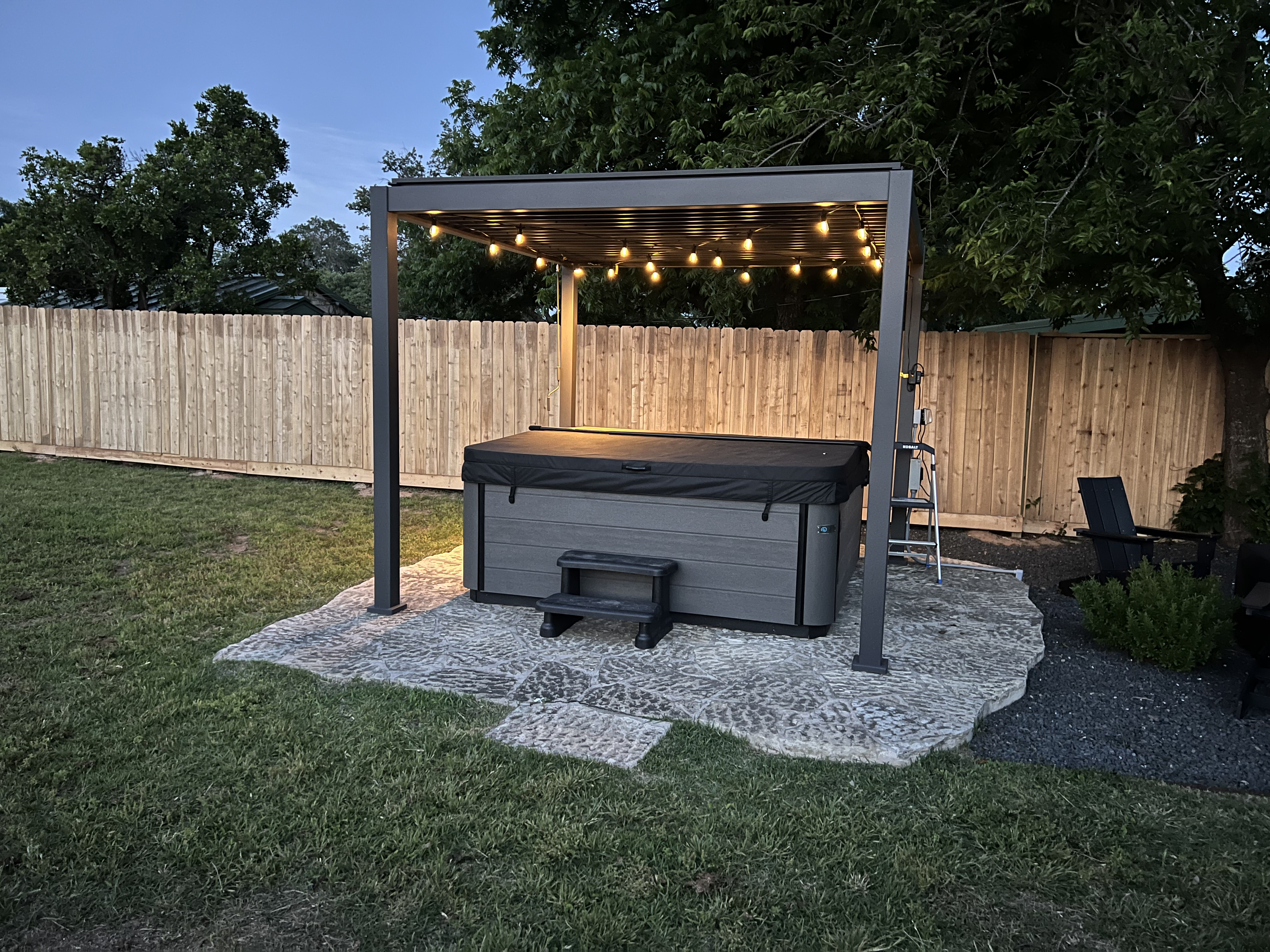 Hot tub pergola with string lights at night